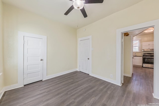 110 Muth, San Antonio, TX 78208 - unfurnished bedroom featuring dark wood-style flooring, baseboards, a sink, and a ceiling fan