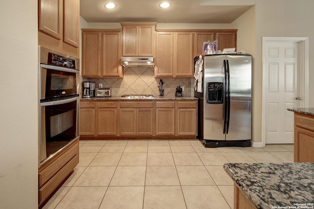 6139 Diego Ln, San Antonio, TX 78253 - kitchen featuring appliances with stainless steel finishes, under cabinet range hood, tasteful backsplash, stone counters, and light tile patterned flooring