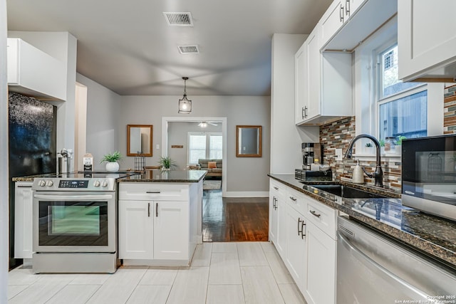 719 W Elsmere, San Antonio, TX 78212 - kitchen featuring stainless steel appliances, a sink, backsplash, white cabinets, and a peninsula