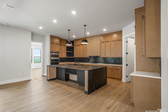 25822 Mount Carillon, San Antonio, TX 78260 - kitchen featuring stainless steel double oven, decorative backsplash, an island with sink, recessed lighting, and light wood-style flooring