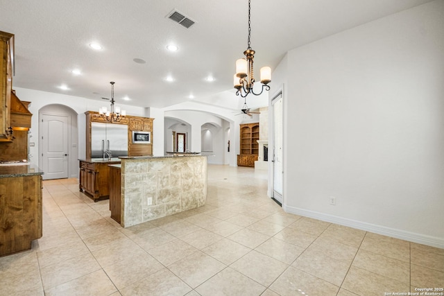 102 Arroyo, Boerne, TX 78006 - kitchen featuring arched walkways, a chandelier, built in appliances, an island with sink, and light tile patterned flooring