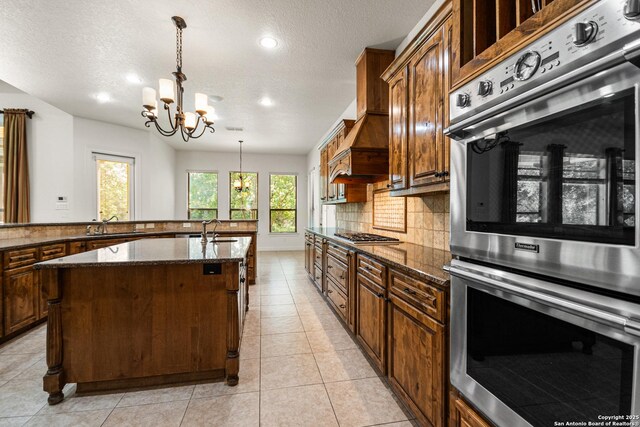 102 Arroyo, Boerne, TX 78006 - kitchen with appliances with stainless steel finishes, a chandelier, a kitchen island with sink, recessed lighting, and backsplash