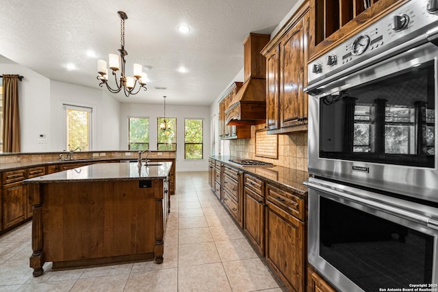 102 Arroyo, Boerne, TX 78006 - kitchen with stainless steel appliances, an island with sink, a chandelier, recessed lighting, and tasteful backsplash