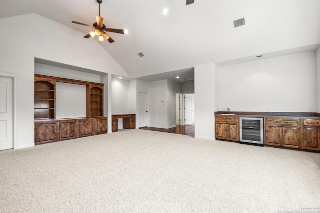 102 Arroyo, Boerne, TX 78006 - unfurnished living room featuring beverage cooler, a ceiling fan, high vaulted ceiling, bar with sink, and carpet