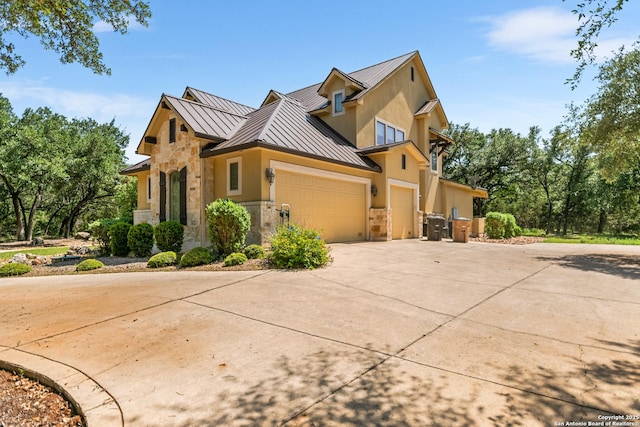 102 Arroyo, Boerne, TX 78006 - view of side of property featuring a standing seam roof, metal roof, concrete driveway, and stone siding