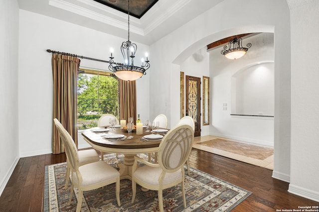 102 Arroyo, Boerne, TX 78006 - dining area featuring arched walkways, hardwood / wood-style floors, a chandelier, crown molding, and baseboards