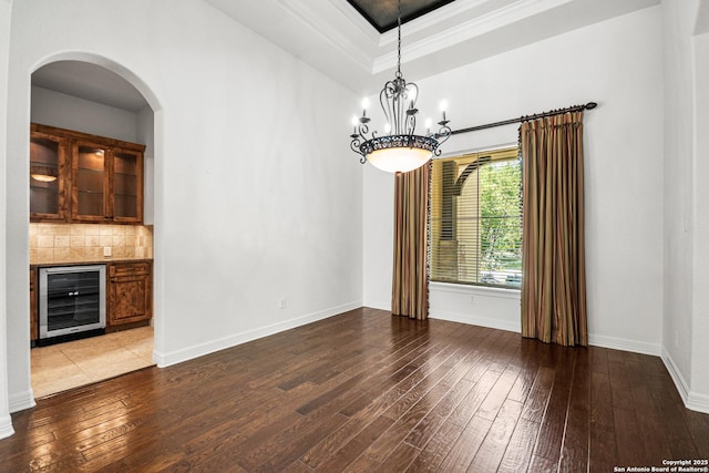102 Arroyo, Boerne, TX 78006 - empty room featuring beverage cooler, hardwood / wood-style flooring, arched walkways, baseboards, and a chandelier