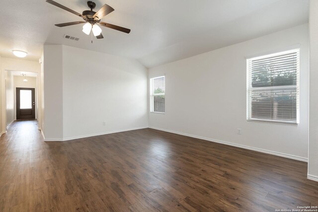 spare room featuring a ceiling fan, dark wood-type flooring, baseboards, and lofted ceiling