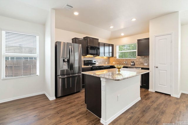 kitchen featuring stainless steel fridge with ice dispenser, black microwave, electric range oven, a center island, and backsplash