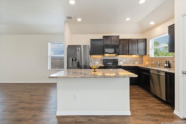 kitchen featuring black appliances, a kitchen island, tasteful backsplash, dark wood-style floors, and recessed lighting