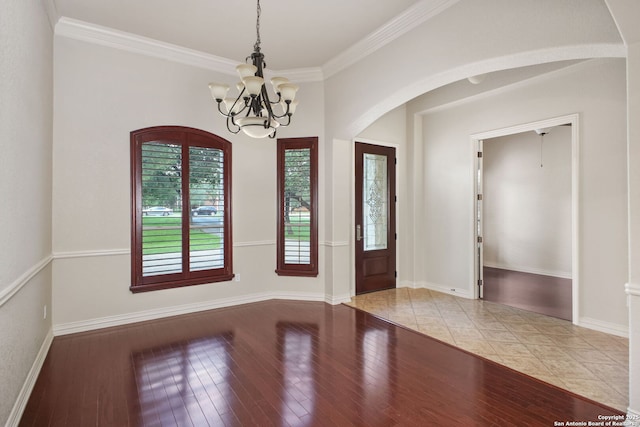 19015 Seminole Pass, Garden Ridge, TX 78266 - foyer entrance featuring a chandelier, arched walkways, light wood finished floors, crown molding, and baseboards
