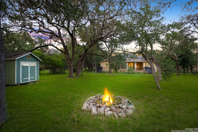 19015 Seminole Pass, Garden Ridge, TX 78266 - yard at dusk with a fire pit and a lawn