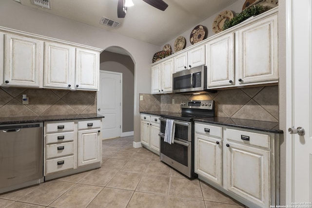 212 Leather Leaf, Boerne, TX 78006 - kitchen featuring stainless steel appliances, a ceiling fan, arched walkways, light tile patterned floors, and decorative backsplash