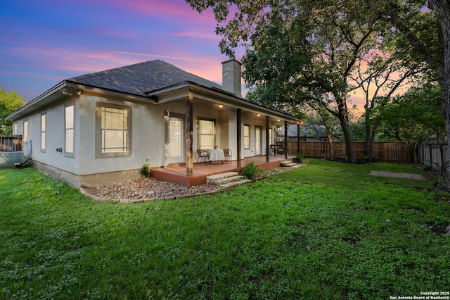 212 Leather Leaf, Boerne, TX 78006 - back of property at dusk featuring a chimney, roof with shingles, stucco siding, and covered porch