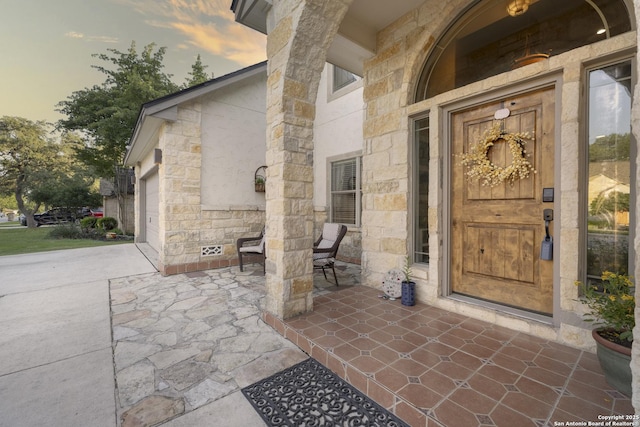 212 Leather Leaf, Boerne, TX 78006 - exterior entry at dusk with stone siding, covered porch, and a garage