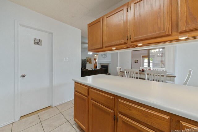 718 Cypressgreen, San Antonio, TX 78245 - kitchen featuring light tile patterned floors, light countertops, and a fireplace