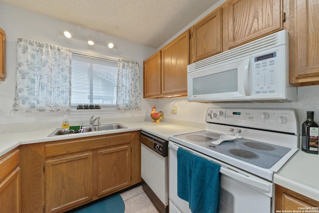 718 Cypressgreen, San Antonio, TX 78245 - kitchen with white appliances, a sink, light tile patterned floors, a textured ceiling, and light countertops