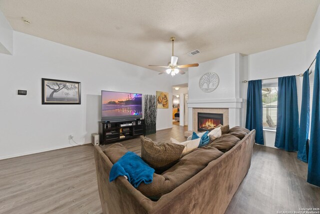 718 Cypressgreen, San Antonio, TX 78245 - living area with wood finished floors, a fireplace, a ceiling fan, a textured ceiling, and baseboards