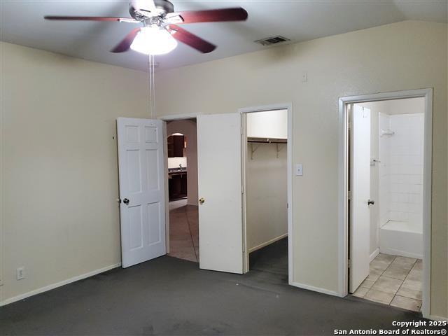 4218 Swan Frst, San Antonio, TX 78222 - unfurnished bedroom with arched walkways, lofted ceiling, ensuite bathroom, a closet, and a spacious closet