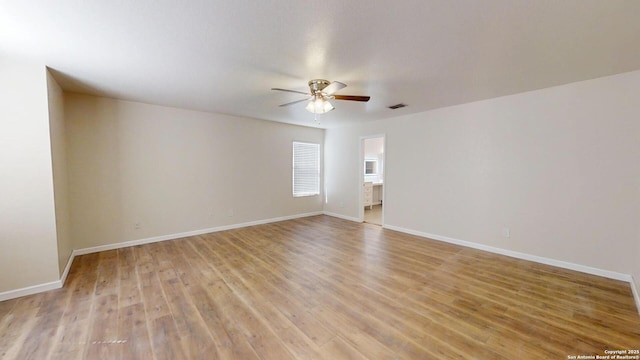 unfurnished room with a ceiling fan, light wood-type flooring, and baseboards