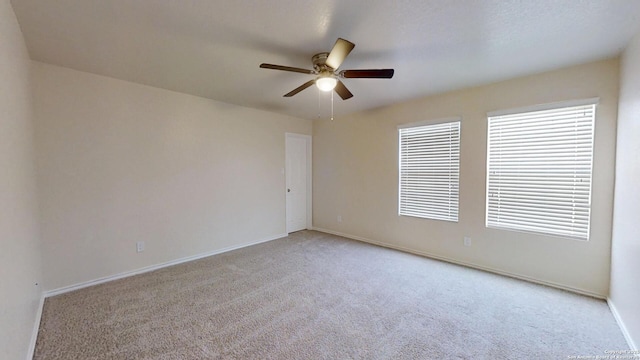 empty room with carpet, ceiling fan, and baseboards