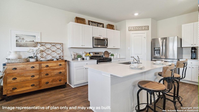 5026 Wichita Pike, San Antonio, TX 78253 - kitchen with appliances with stainless steel finishes, a sink, dark wood-style floors, a breakfast bar area, and light countertops