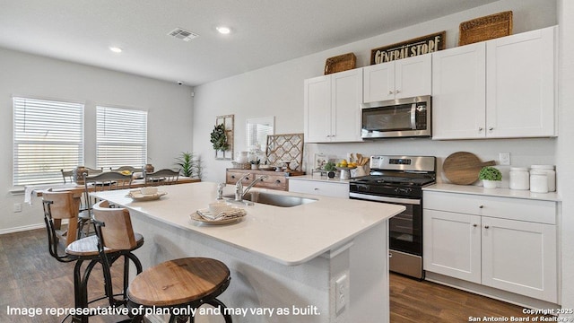 5026 Wichita Pike, San Antonio, TX 78253 - kitchen with stainless steel appliances, a sink, dark wood-type flooring, a kitchen breakfast bar, and light countertops