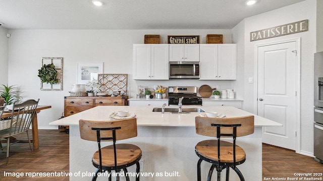 5026 Wichita Pike, San Antonio, TX 78253 - kitchen with appliances with stainless steel finishes, dark wood finished floors, a kitchen breakfast bar, recessed lighting, and white cabinetry