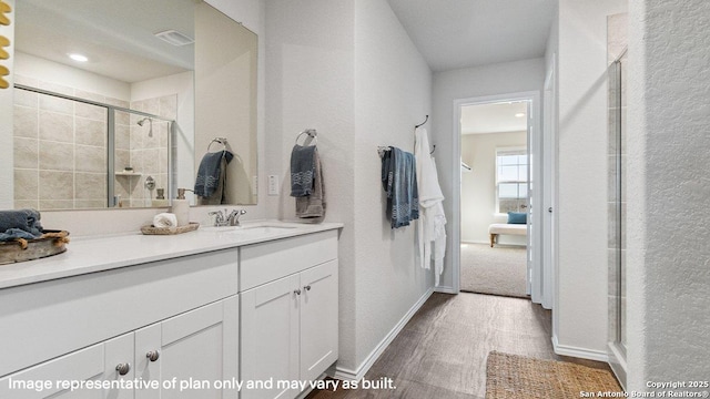 5026 Wichita Pike, San Antonio, TX 78253 - bathroom with tiled shower, vanity, baseboards, and wood finished floors