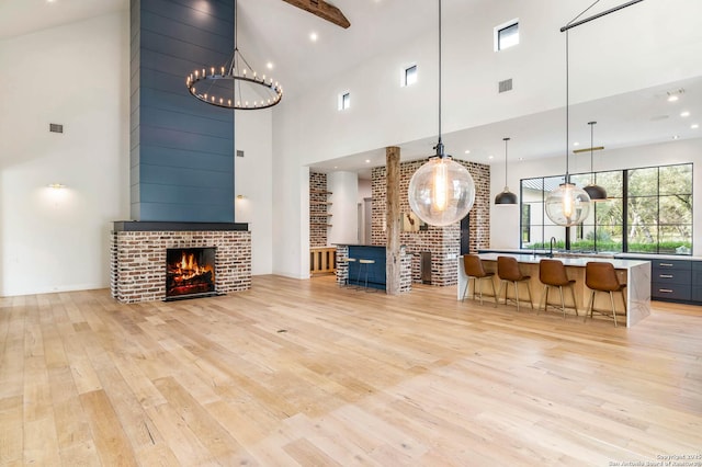 185 Southfield, Boerne, TX 78006 - living room featuring a high ceiling, a brick fireplace, light wood-type flooring, a chandelier, and recessed lighting