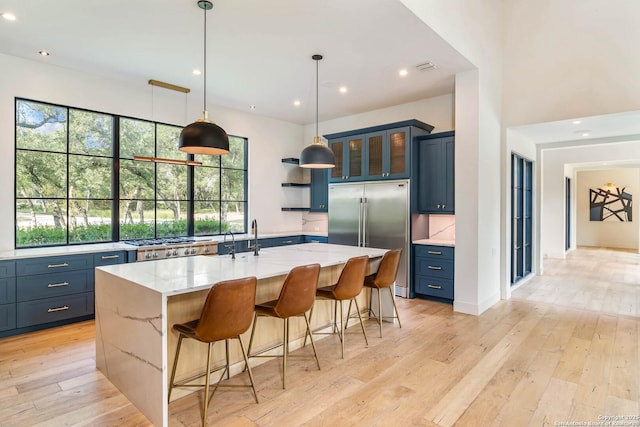 185 Southfield, Boerne, TX 78006 - kitchen featuring built in refrigerator, healthy amount of natural light, blue cabinetry, light wood-type flooring, and recessed lighting
