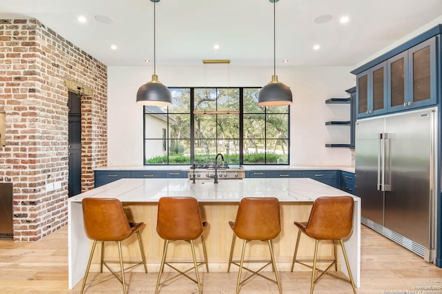 185 Southfield, Boerne, TX 78006 - kitchen with stainless steel built in refrigerator, open shelves, a sink, light stone countertops, and light wood-style flooring