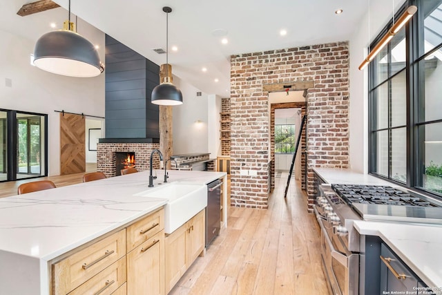 185 Southfield, Boerne, TX 78006 - kitchen featuring stainless steel appliances, a sink, light wood-type flooring, healthy amount of natural light, and brick wall