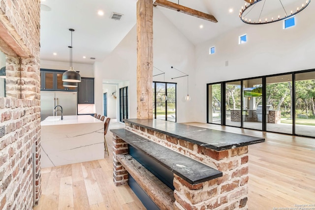 185 Southfield, Boerne, TX 78006 - kitchen featuring stainless steel built in fridge, high vaulted ceiling, light wood-type flooring, hanging light fixtures, and glass insert cabinets
