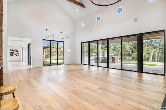 185 Southfield, Boerne, TX 78006 - unfurnished living room with high vaulted ceiling, light wood finished floors, and a chandelier