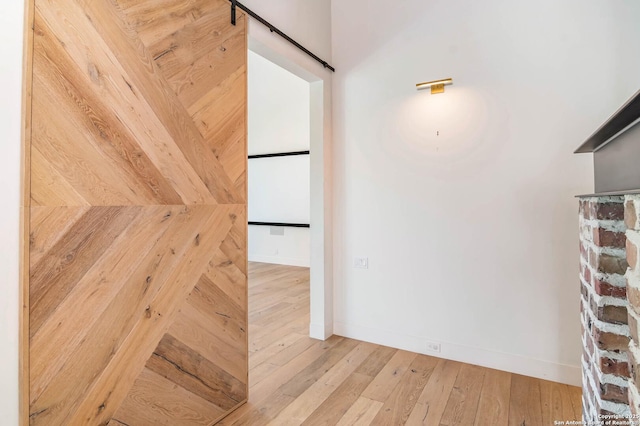 185 Southfield, Boerne, TX 78006 - corridor featuring wood-type flooring, a barn door, and baseboards