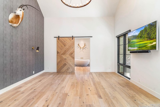 185 Southfield, Boerne, TX 78006 - unfurnished living room with wood-type flooring, a chandelier, high vaulted ceiling, and baseboards