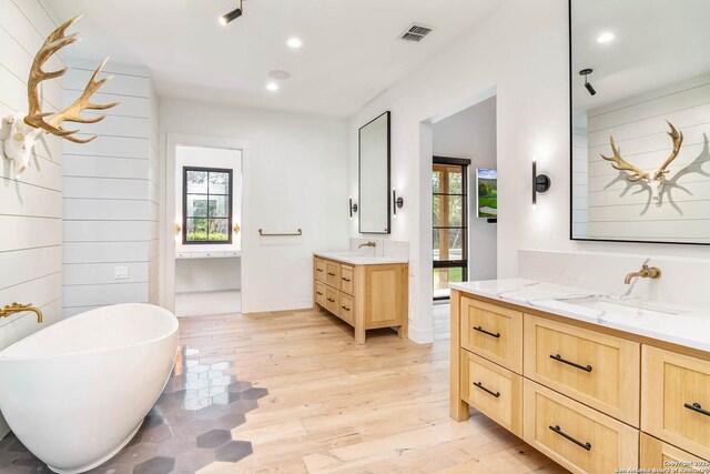 185 Southfield, Boerne, TX 78006 - bathroom with wood finished floors, recessed lighting, two vanities, and a freestanding tub