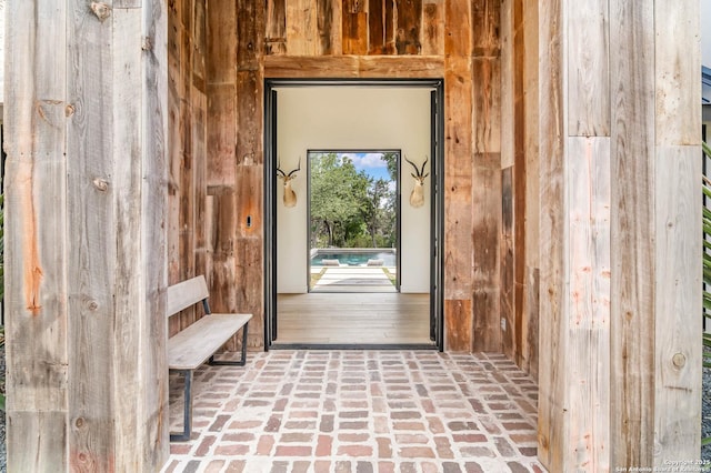 185 Southfield, Boerne, TX 78006 - doorway featuring wood walls and brick floors