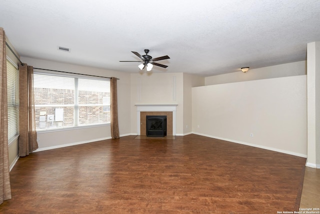 unfurnished living room featuring a ceiling fan, wood finished floors, a tile fireplace, and baseboards