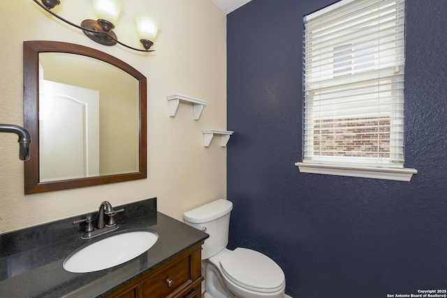 half bathroom with vanity and toilet
