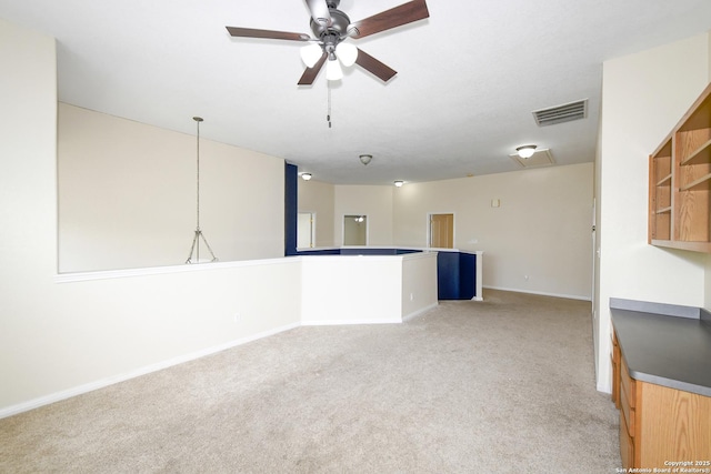 unfurnished living room featuring light carpet, a ceiling fan, and baseboards