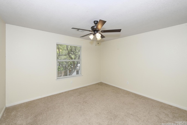 empty room featuring light carpet, a ceiling fan, and baseboards