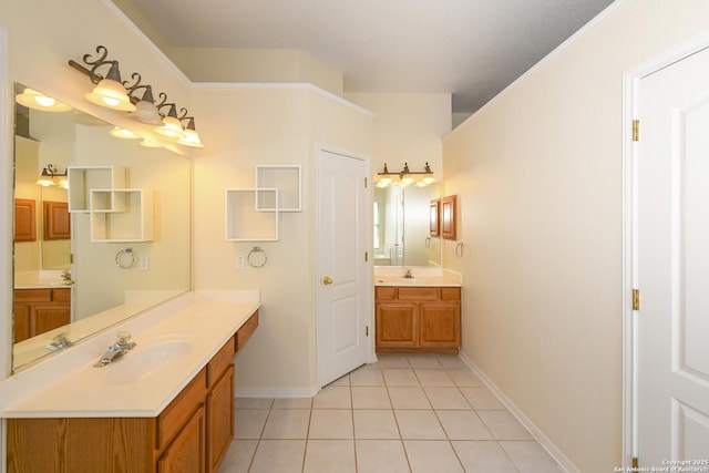 bathroom with baseboards, tile patterned flooring, and two vanities