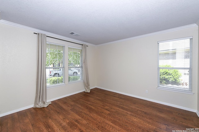spare room featuring ornamental molding, dark wood-style floors, and baseboards