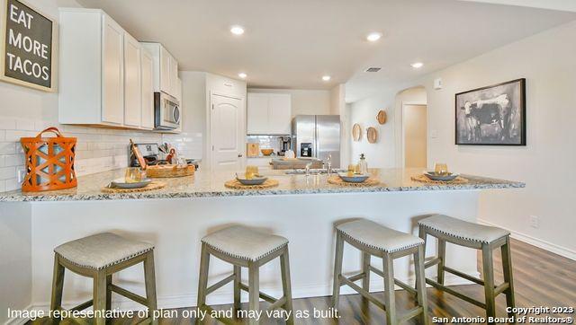 12123 Jasper Strm, San Antonio, TX 78245 - kitchen with appliances with stainless steel finishes, light stone countertops, white cabinets, and recessed lighting