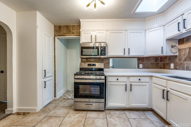 827 Ware Blvd, San Antonio, TX 78214 - kitchen with stainless steel appliances, arched walkways, light countertops, and backsplash