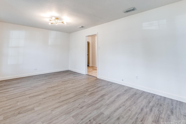 827 Ware Blvd, San Antonio, TX 78214 - spare room featuring wood finished floors, baseboards, arched walkways, and a textured ceiling