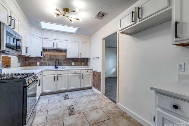 827 Ware Blvd, San Antonio, TX 78214 - kitchen with appliances with stainless steel finishes, a sink, light countertops, and white cabinetry