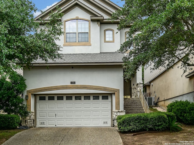 1215 Cresswell Cv, San Antonio, TX 78258 - view of front facade with stucco siding, central AC unit, driveway, a garage, and stairs
